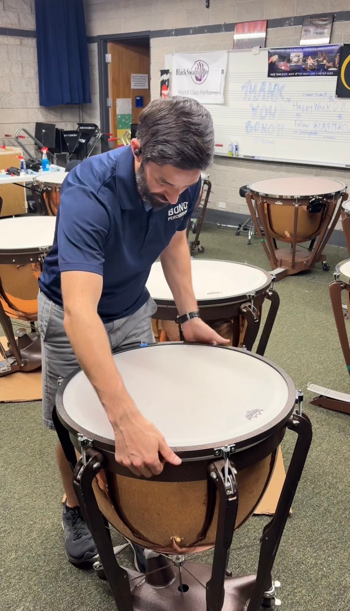 A Bono Percussion technician checking counter hoop distance on a timpani