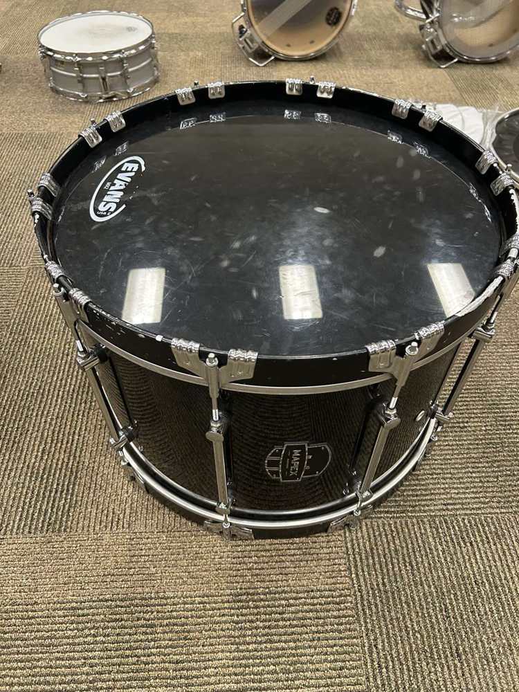 A marching bass drum before service, the old batter head scuffed and worn