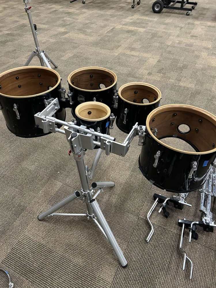 A set of marching tenors before service, all the heads off and the shells bare on the carrier stand