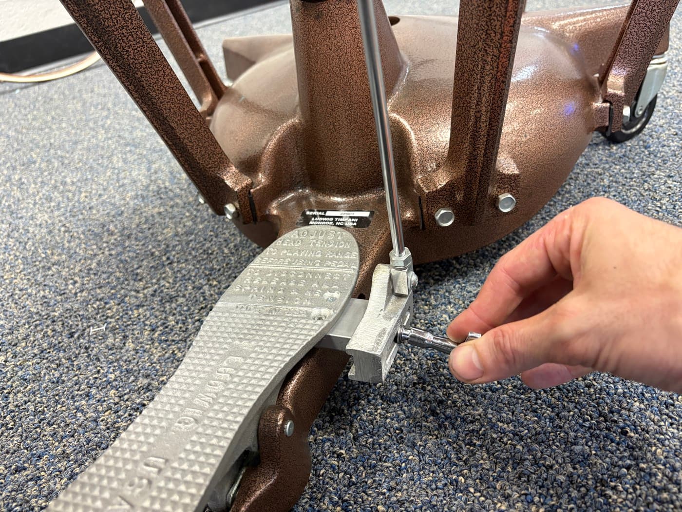 A technician adjusting the tuning gauge on a timpani