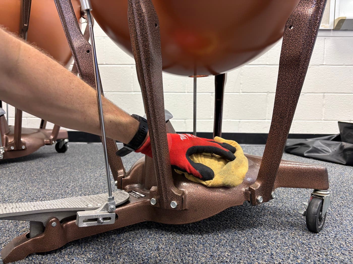 A technician cleaning the base of a timpani