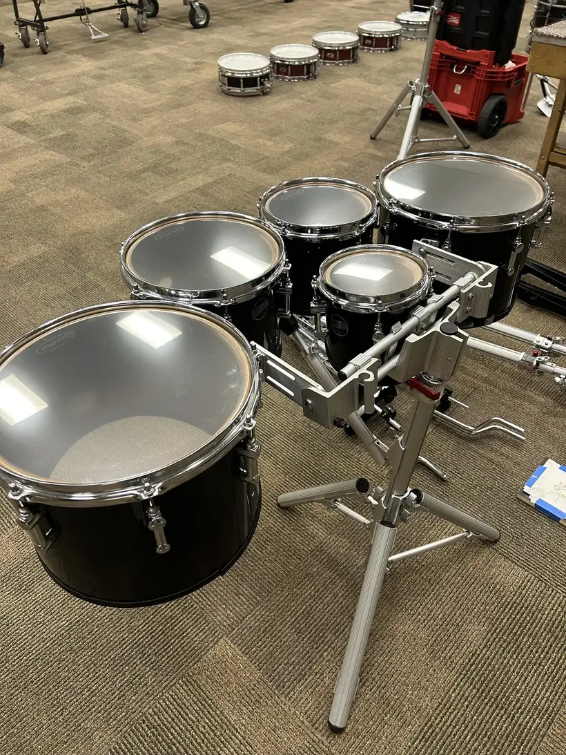 A set of marching tenors with fresh heads installed, ready to tune