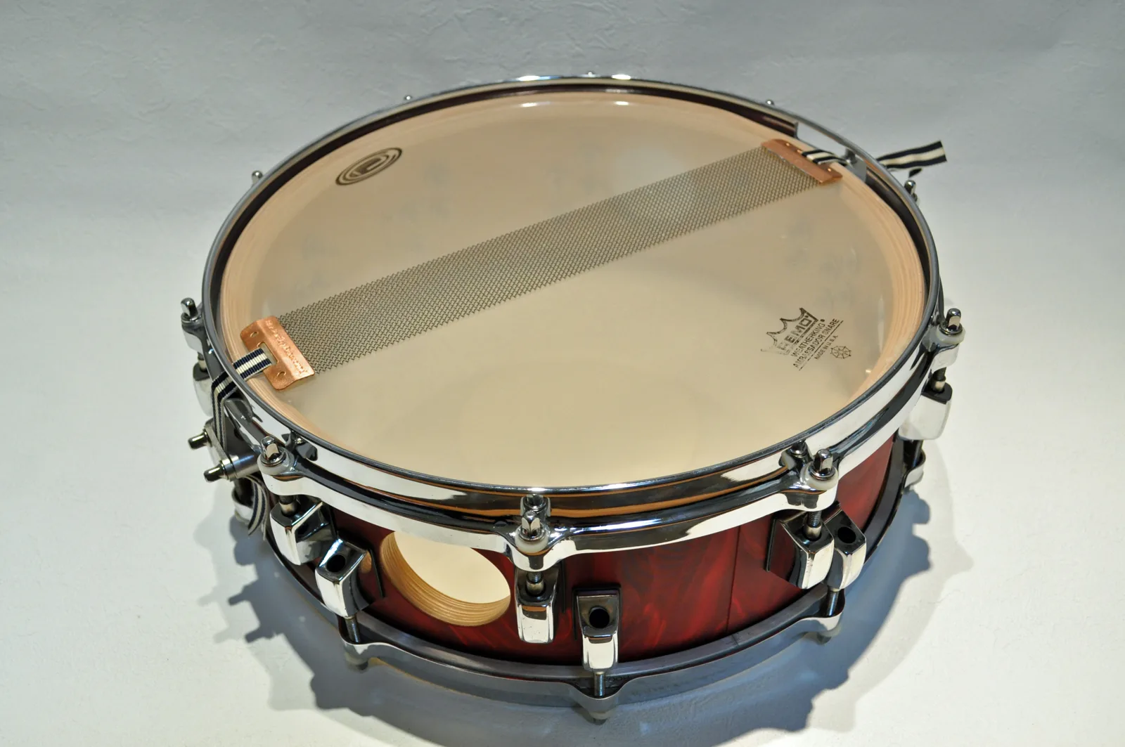 Close-up of a snare drum's resonant head and snare wires